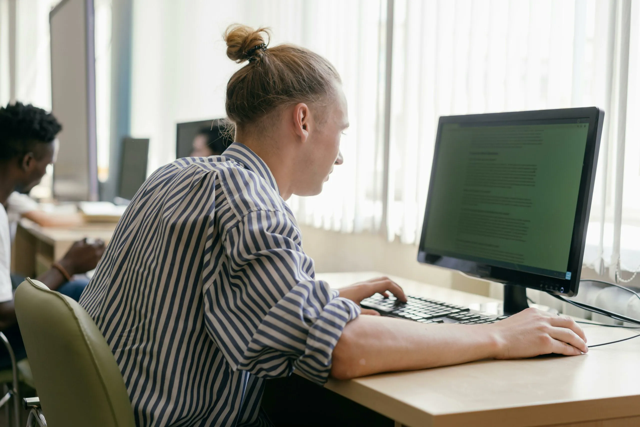 A person sitting at a computer reviewing their Archer Review NCLEX Adaptive Test