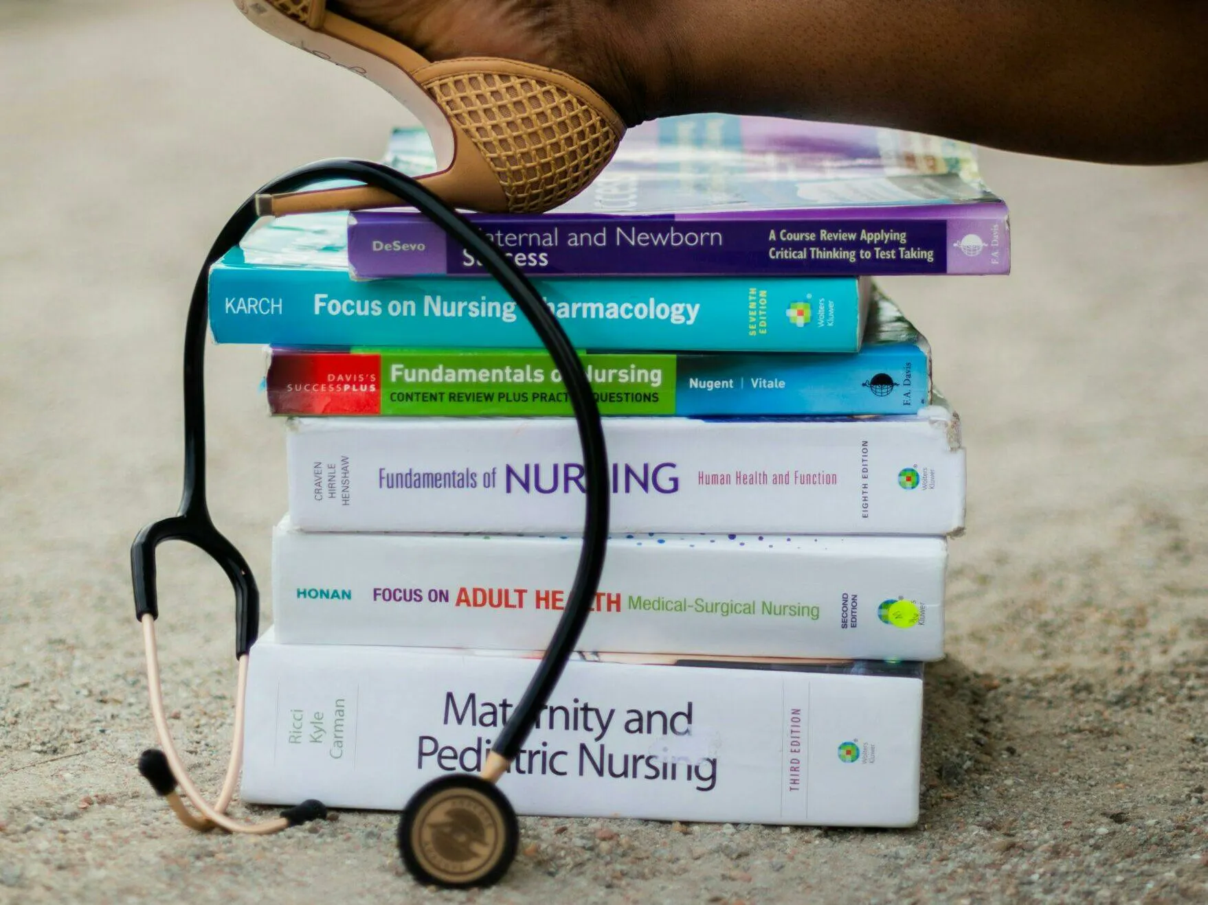 Stack of nursing textbooks with a stethoscope representing TEAS reading practice tests for future nurses