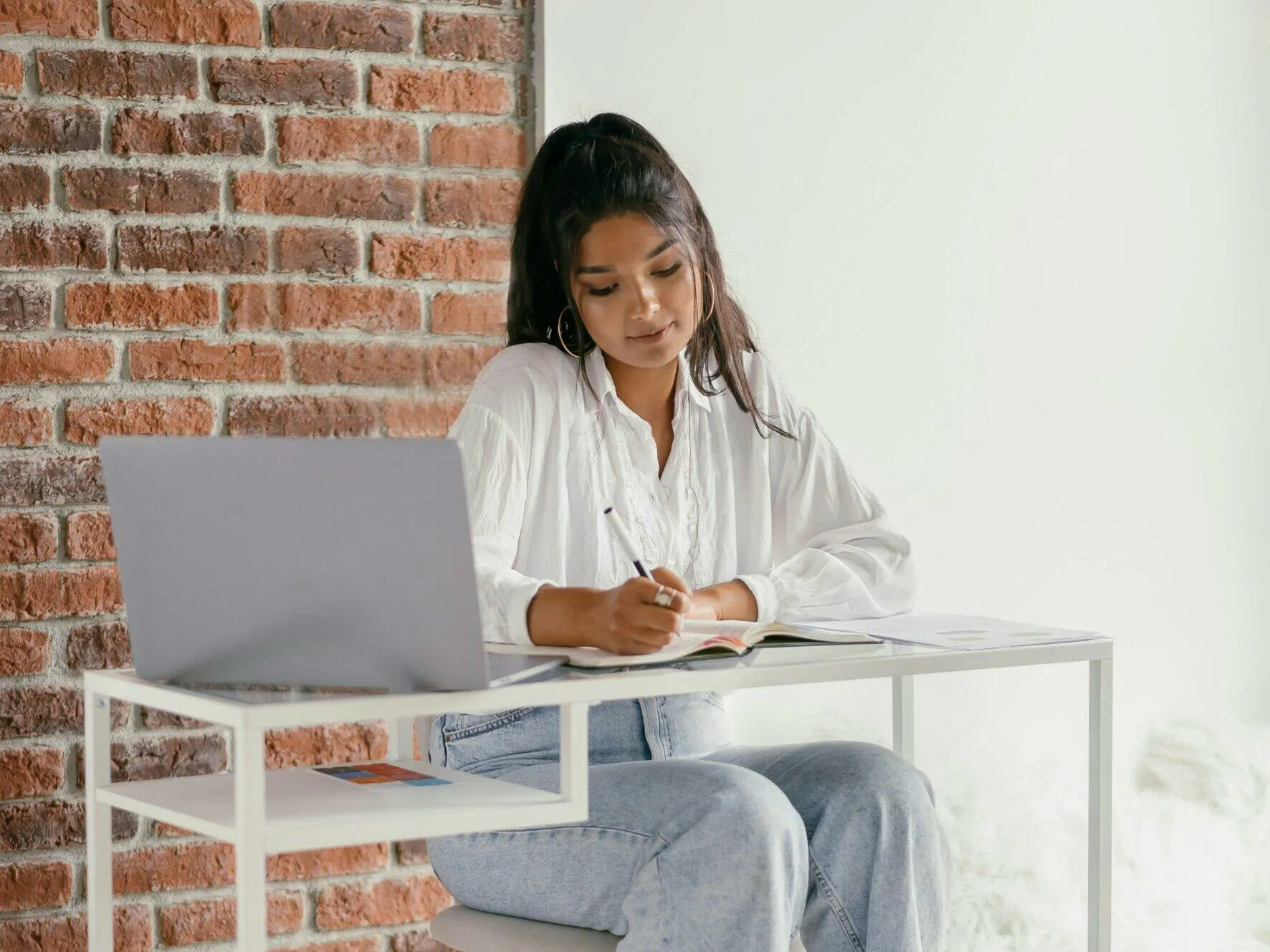 Nurse practitioner studying for the FNP certification exam with notes and a laptop