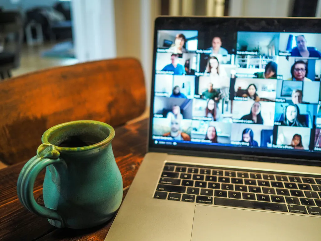 Laptop showing a video call grid beside a coffee mug, promoting the free webinar on FNP certification exam changes