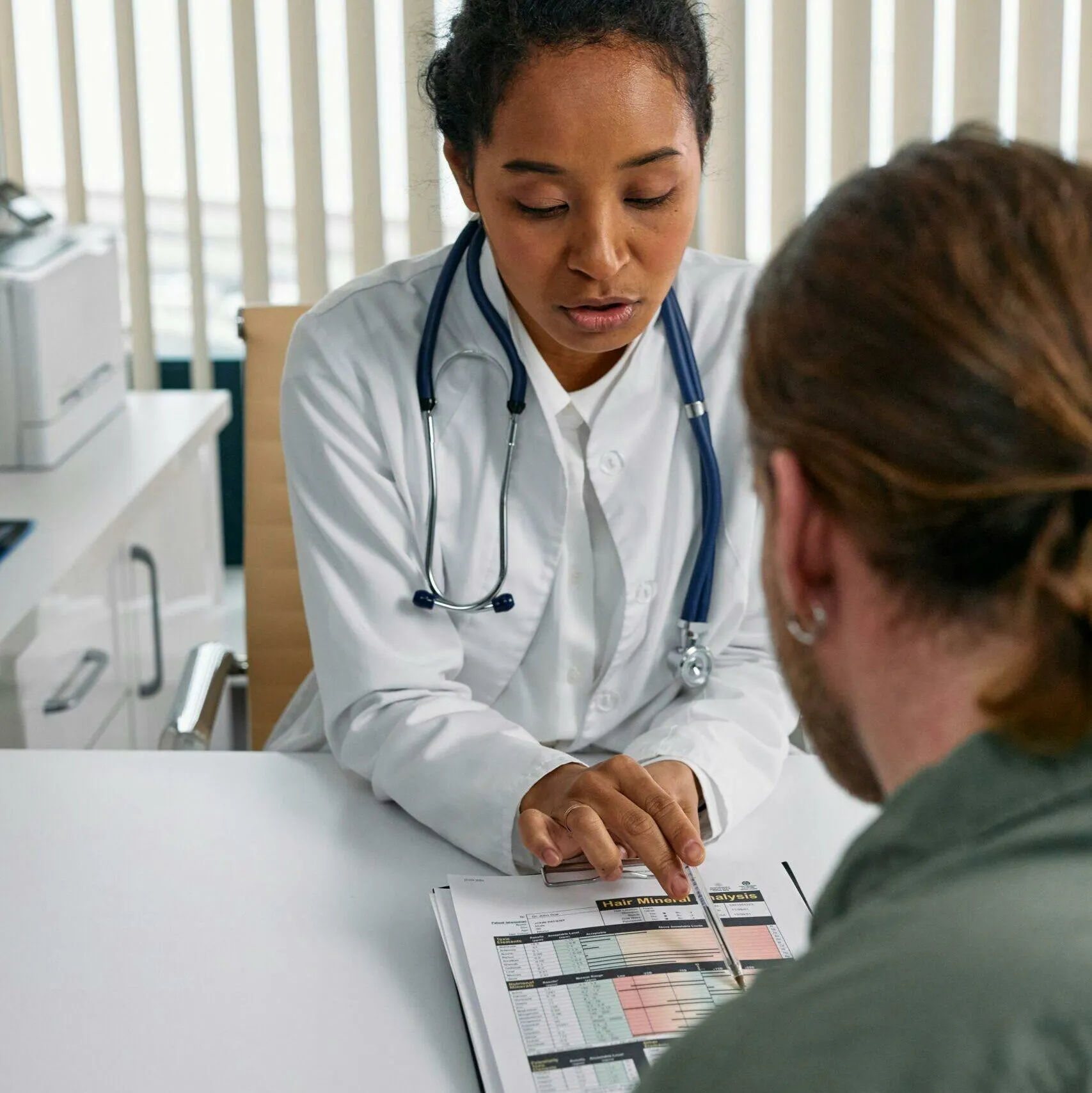 Clinician reviewing a lab report with a patient, illustrating the kind of case scenario used on the FNP certification exam