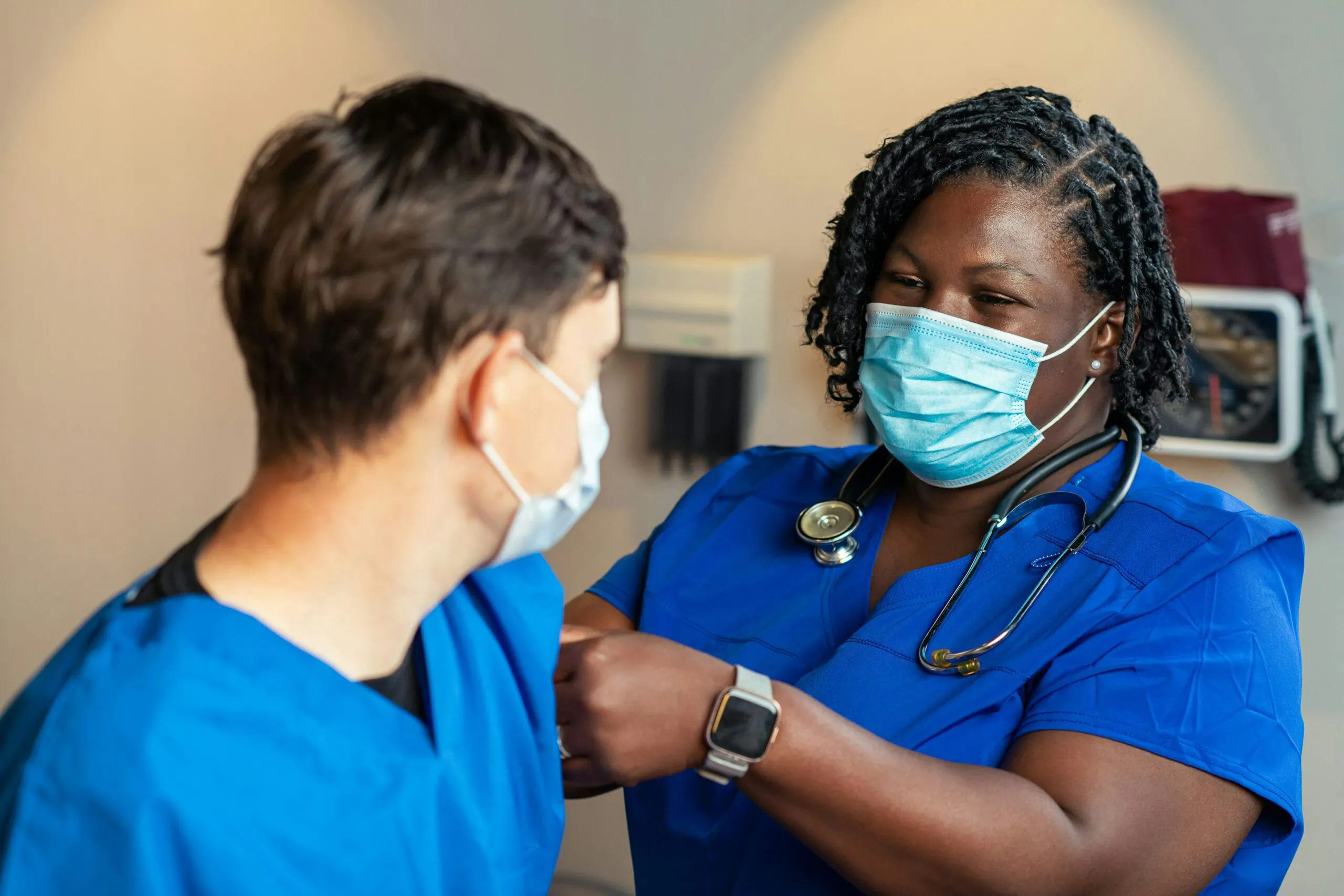 First-year nurse practitioner receiving guidance from an experienced colleague in a clinic