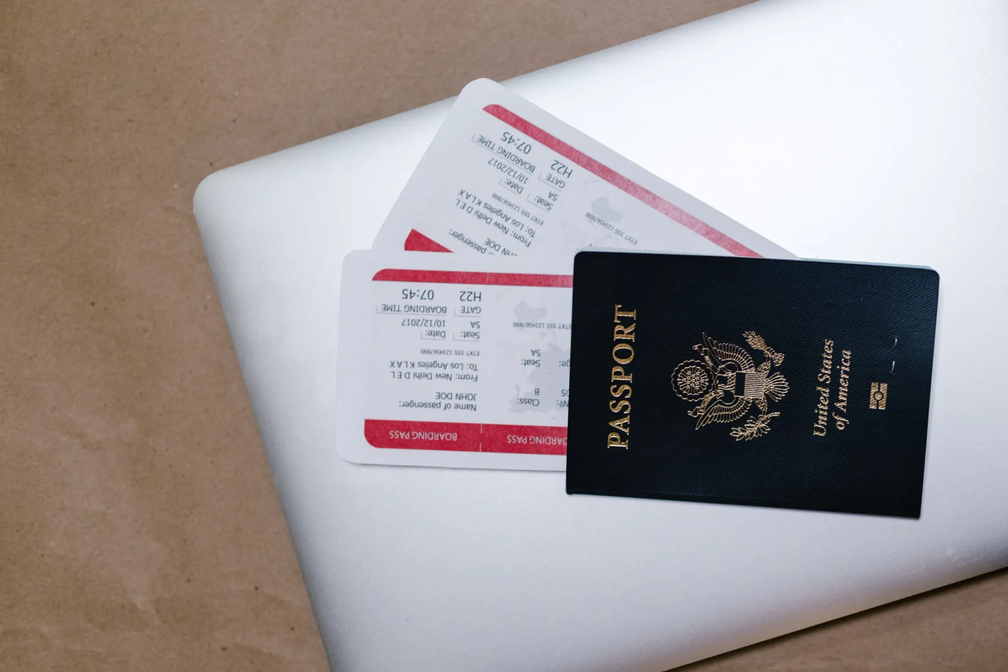 US passport and boarding passes on a laptop illustrating travel expenses beyond the NCLEX exam cost