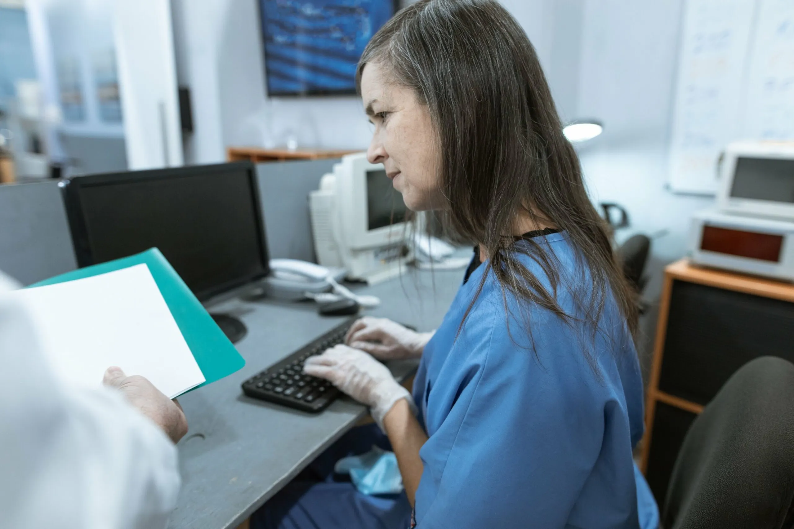 Nurse in scrubs reviewing patient information at a computer, similar to working through an NGN case study